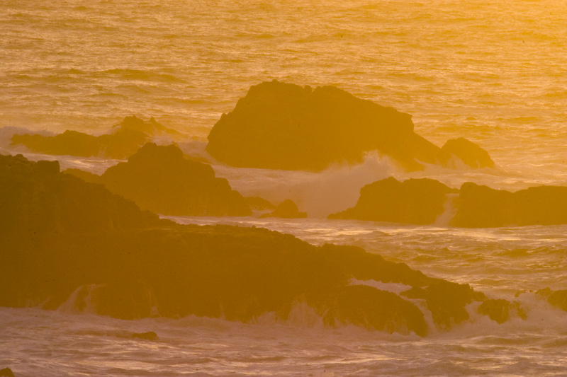 Waves Breaking Over Rocks At Sunset